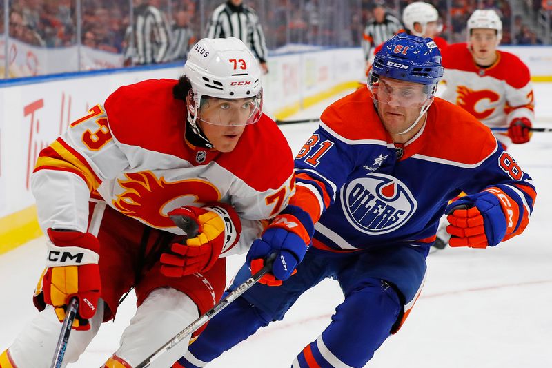 Sep 23, 2024; Edmonton, Alberta, CAN; Calgary Flames forward Jaden Lipinski (73) and Edmonton Oilers defensemen Noel Hoefenmayer (81) battle for a loose puck during the second period at Rogers Place. Mandatory Credit: Perry Nelson-Imagn Images