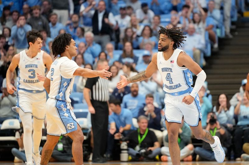 Dec 2, 2023; Chapel Hill, North Carolina, USA;  North Carolina Tar Heels guard Elliot Cadeau (2) reacts with guard RJ Davis (4) in the first half at Dean E. Smith Center. Mandatory Credit: Bob Donnan-USA TODAY Sports