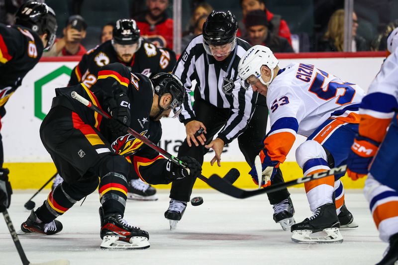 Nov 19, 2024; Calgary, Alberta, CAN; Calgary Flames center Nazem Kadri (91) and New York Islanders center Casey Cizikas (53) face off for the puck during the third period at Scotiabank Saddledome. Mandatory Credit: Sergei Belski-Imagn Images