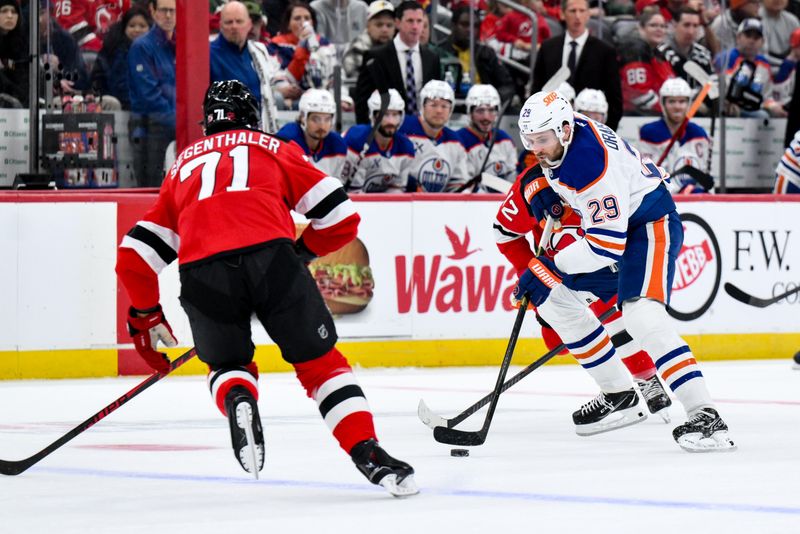 Oct 18, 2025; Newark, New Jersey, USA; Edmonton Oilers center Leon Draisaitl (29) skates with the puck while defended by New Jersey Devils center Cody Glass (12) during the first period at Prudential Center. Mandatory Credit: John Jones-Imagn Images