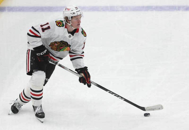 Apr 8, 2025; Pittsburgh, Pennsylvania, USA;  Chicago Blackhawks center Oliver Moore (11) skates with the puck against the Pittsburgh Penguins during the second period at PPG Paints Arena. Mandatory Credit: Charles LeClaire-Imagn Images
