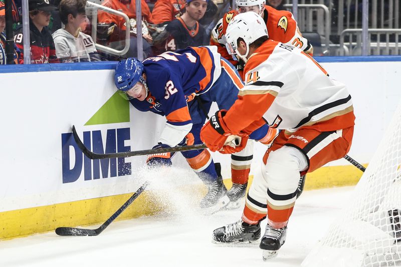 Oct 29, 2024; Elmont, New York, USA;  New York Islanders center Kyle MacLean (32) and Anaheim Ducks defenseman Cam Fowler (4) battle for control of the puck in the second period at UBS Arena. Mandatory Credit: Wendell Cruz-Imagn Images