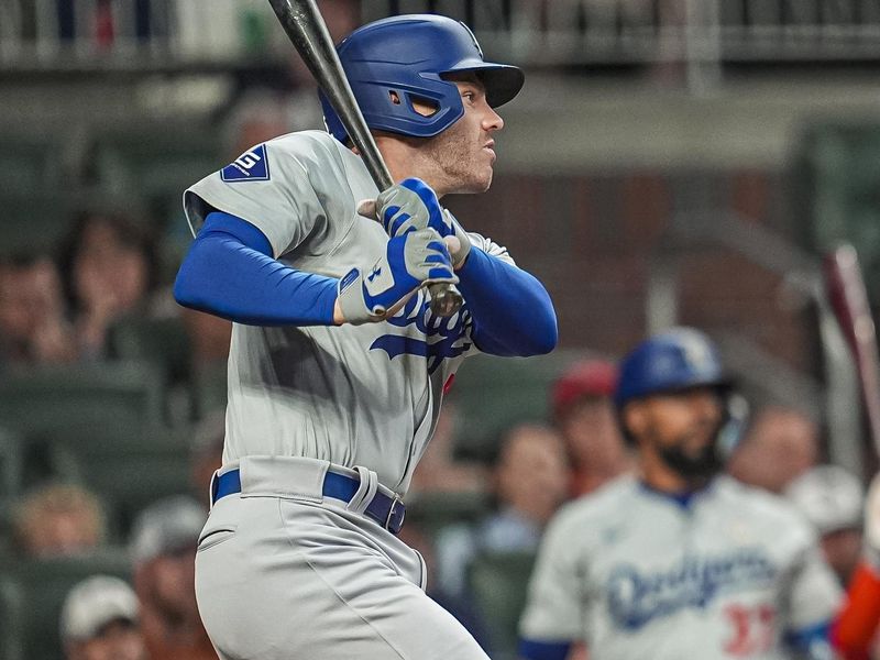 Sep 15, 2024; Cumberland, Georgia, USA; Los Angeles Dodgers first baseman Freddie Freeman (5) singles to drive in a run against the Atlanta Braves during the ninth inning at Truist Park. Mandatory Credit: Dale Zanine-Imagn Images