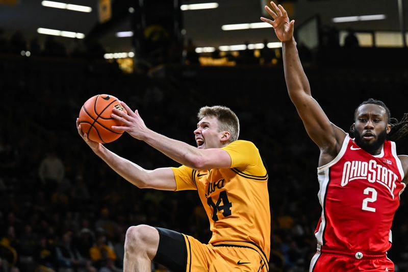 Feb 25, 2026; Iowa City, Iowa, USA; Iowa Hawkeyes guard Bennett Stirtz (14) goes to the basket as Ohio State Buckeyes guard Bruce Thornton (2) defends during the second half at Carver-Hawkeye Arena. Mandatory Credit: Jeffrey Becker-Imagn Images