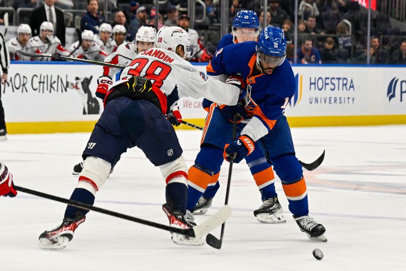Nov 30, 2025; Elmont, New York, USA;  Washington Capitals defenseman Rasmus Sandin (38) defends against New York Islanders left wing Anthony Duclair (11) during the second period at UBS Arena. Mandatory Credit: Dennis Schneidler-Imagn Images