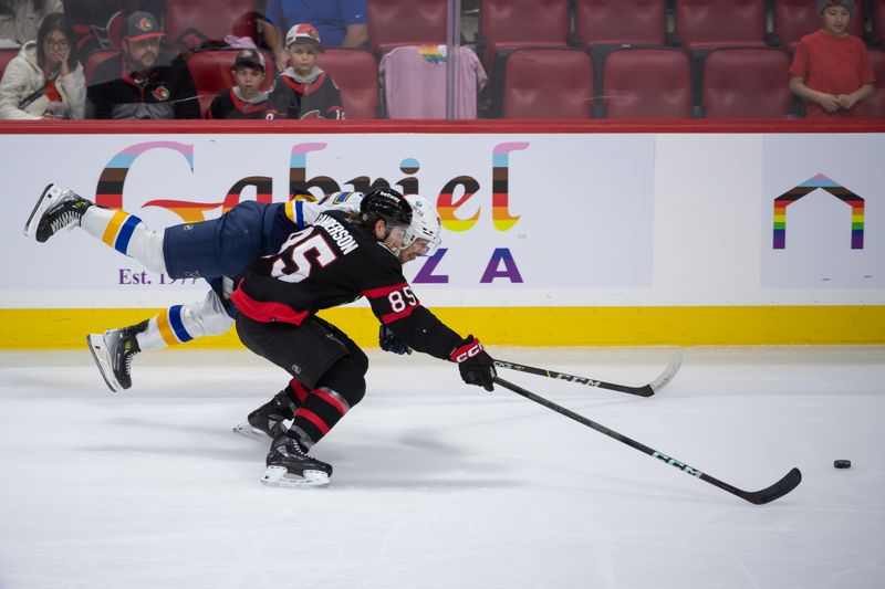 Mar 21, 2024; Ottawa, Ontario, CAN; St. Louis Blues center Jordan Kyrou (25) tries to get to the puck as he battles with Ottawa Senators defenseman Jake Sanderson (85) in the third period at the Canadian Tire Centre. Mandatory Credit: Marc DesRosiers-USA TODAY Sports