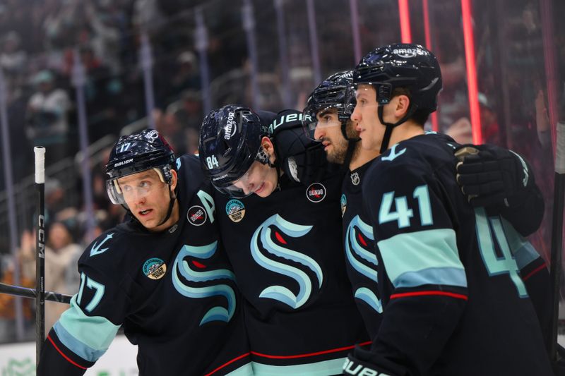 Jan 25, 2025; Seattle, Washington, USA; Seattle Kraken center Jaden Schwartz (17) and right wing Kaapo Kakko (84) and center Matty Beniers (10) and defenseman Ryker Evans (41) celebrate after Beniers scored a goal against the Pittsburgh Penguins during the third period at Climate Pledge Arena. Mandatory Credit: Steven Bisig-Imagn Images