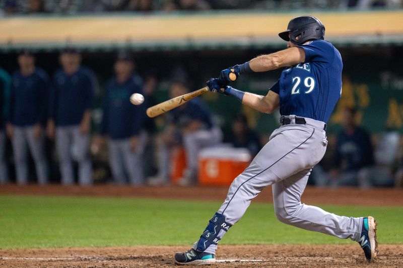 Sep 19, 2023; Oakland, California, USA; Seattle Mariners catcher Cal Raleigh (29) hits a single against the Oakland Athletics during the seventh inning at Oakland-Alameda County Coliseum. Mandatory Credit: Neville E. Guard-USA TODAY Sports