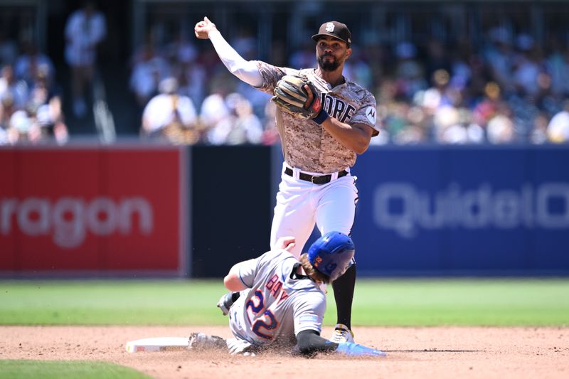 Jul 9, 2023; San Diego, California, USA; San Diego Padres shortstop Xander Bogaerts (top) throws to first base after forcing out New York Mets third baseman Brett Baty (22) at second base to complete a double play during the fifth inning at Petco Park. Mandatory Credit: Orlando Ramirez-USA TODAY Sports