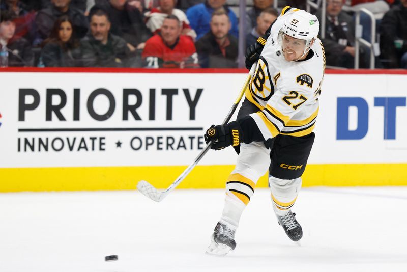 Dec 2, 2025; Detroit, Michigan, USA;  Boston Bruins defenseman Hampus Lindholm (27) takes a shot in the third period against the Detroit Red Wings at Little Caesars Arena. Mandatory Credit: Rick Osentoski-Imagn Images