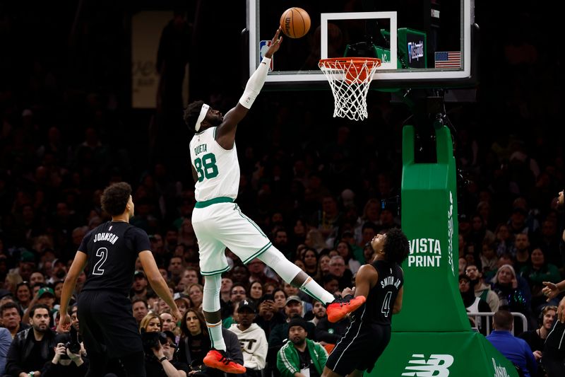 BOSTON, MA - FEBRUARY 14: As Dennis Smith Jr. #4 of the Brooklyn Nets and Cameron Johnson #2 look on, Neemias Queta #88 of the Boston Celtics lays the ball in during the second half at TD Garden on February 14, 2024 in Boston, Massachusetts. NOTE TO USER: User expressly acknowledges and agrees that, by downloading and/or using this Photograph, user is consenting to the terms and conditions of the Getty Images License Agreement. (Photo By Winslow Townson/Getty Images)