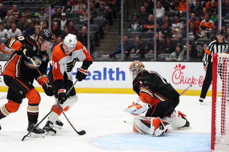 Nov 10, 2023; Anaheim, California, USA; Philadelphia Flyers right wing Owen Tippett (74) and Anaheim Ducks defenseman Jackson LaCombe (60) battles for the puck as Anaheim Ducks goaltender Lukas Dostal (1) protects a goal during the first period at Honda Center. Mandatory Credit: Kiyoshi Mio-USA TODAY Sports