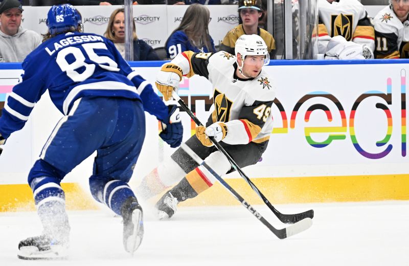 Feb 27, 2024; Toronto, Ontario, CAN;  Vegas Golden Knights forward Ivan Barbashev (49) turns with the puck against Toronto Maple Leafs defenseman William Lagesson (85) in the second period at Scotiabank Arena. Mandatory Credit: Dan Hamilton-USA TODAY Sports