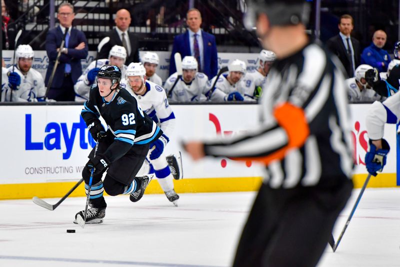 Mar 22, 2025; Salt Lake City, Utah, USA; Utah Hockey Club center Logan Cooley (92) makes breakaway against Tampa Bay Lightning center Zemgus Girgensons (28) during second period at the Delta Center. Mandatory Credit: Peter Creveling-Imagn Images