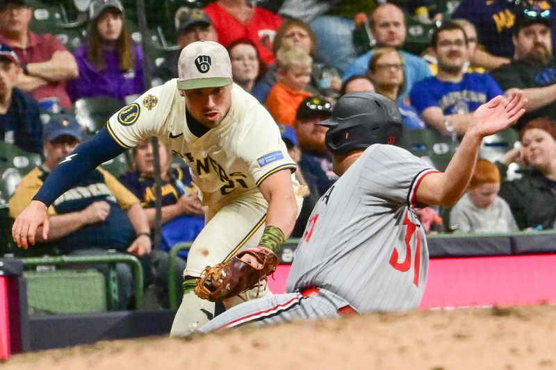 May 17, 2025; Milwaukee, Wisconsin, USA; Milwaukee Brewers third baseman Caleb Durbin (21) tags out  Minnesota Twins third baseman Jonah Bride (31) trying to advance to third base in the eighth inning at American Family Field. Mandatory Credit: Benny Sieu-Imagn Images