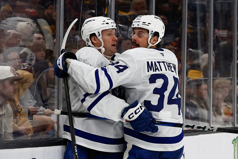 Oct 26, 2024; Boston, Massachusetts, USA; Toronto Maple Leafs center Auston Matthews (34) congratulates defenseman Morgan Rielly (44) after his goal against the Boston Bruins during the second period at TD Garden. Mandatory Credit: Winslow Townson-Imagn Images