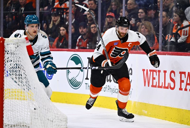 Mar 12, 2024; Philadelphia, Pennsylvania, USA; Philadelphia Flyers center Sean Couturier (14) skates against San Jose Sharks center Nico Sturm (7) in the first period at Wells Fargo Center. Mandatory Credit: Kyle Ross-USA TODAY Sports