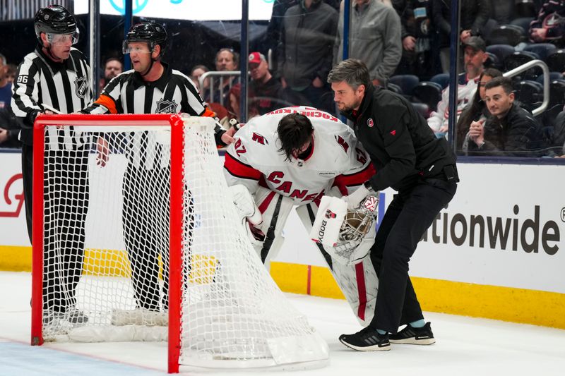 Nov 23, 2024; Columbus, Ohio, USA;  Carolina Hurricanes goaltender Pyotr Kochetkov (52) is tended to by the Hurricanes’ head athletic trainer Doug Bennett during a stop in play in the game against the Columbus Blue Jackets in the overtime period at Nationwide Arena. Mandatory Credit: Aaron Doster-Imagn Images