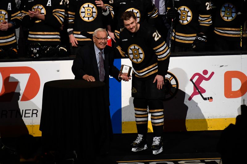 Mar 16, 2024; Boston, Massachusetts, USA; Former Boston Bruins forward Johnny Bucyk presents left wing James van Riemsdyk (21) with an award for playing in his 1000 career game recently prior to a game against the Philadelphia Flyers at TD Garden. Mandatory Credit: Bob DeChiara-USA TODAY Sports