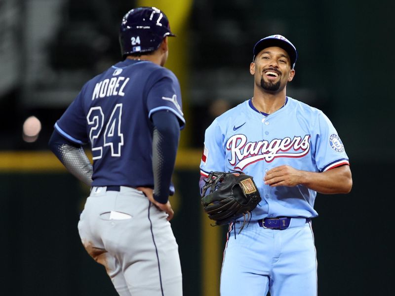 Apr 6, 2025; Arlington, Texas, USA; Texas Rangers second base Marcus Semien (2) smiles at Tampa Bay Rays right fielder Kameron Misner (26) after a play during the second inning at Globe Life Field. Mandatory Credit: Tim Heitman-Imagn Images