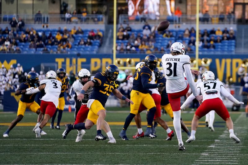 Nov 18, 2023; Morgantown, West Virginia, USA; Cincinnati Bearcats punter Mason Fletcher (31) punts the ball against the West Virginia Mountaineers in the first quarter at Milan Puskar Stadium. West Virginia won 42-21. Mandatory Credit: Kareem Elgazzar-USA TODAY Sports