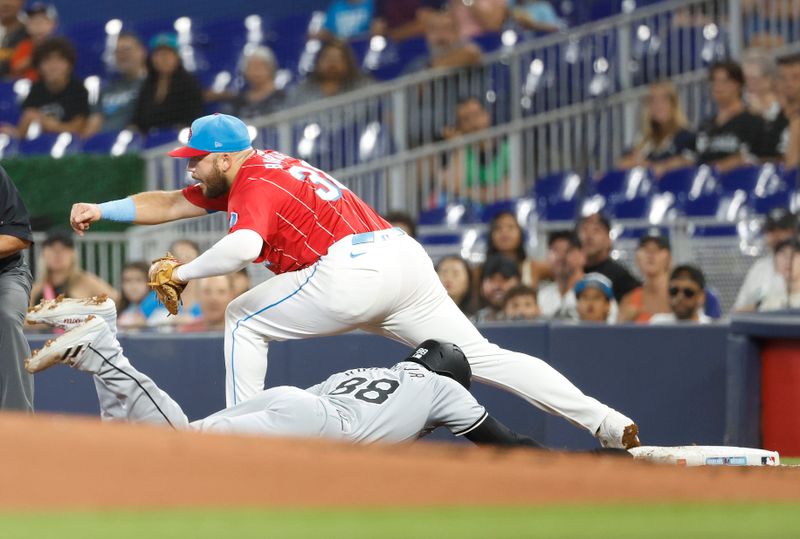 Jul 6, 2024; Miami, Florida, USA;  Miami Marlins first baseman Jake Burger (36) tags out Chicago White Sox center fielder Luis Robert Jr. (88) during the first inning at loanDepot Park. Mandatory Credit: Rhona Wise-USA TODAY Sports