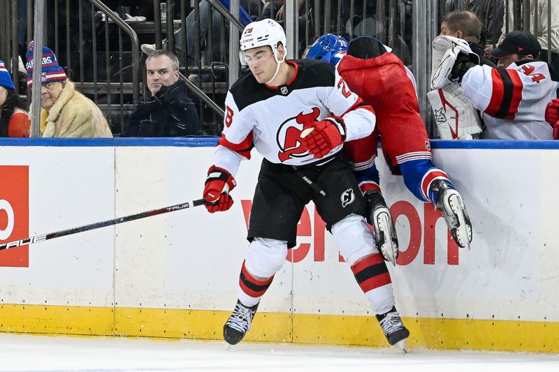 Dec 2, 2024; New York, New York, USA;  New Jersey Devils right wing Timo Meier (28) checks New York Rangers center Filip Chytil (72) into the boards during the third period at Madison Square Garden. Mandatory Credit: Dennis Schneidler-Imagn Images