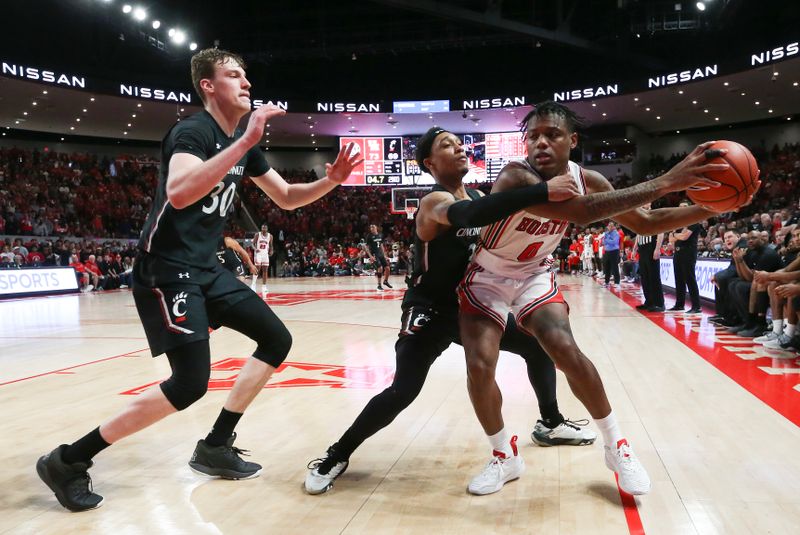 Jan 28, 2023; Houston, Texas, USA; Houston Cougars center Darius Bowser (4) is defended by Cincinnati Bearcats guard Mika Adams-Woods (3) and forward Viktor Lakhin (30) in the second half at Fertitta Center. Houston Cougars won 75 to 69 .Mandatory Credit: Thomas Shea-USA TODAY Sports