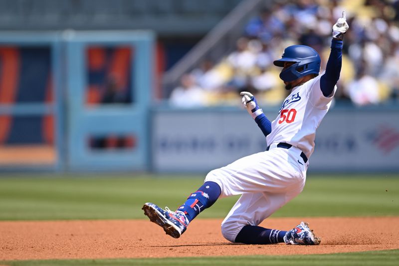Apr 20, 2024; Los Angeles, California, USA; Los Angeles Dodgers shortstop Mookie Betts (50) slides into second base against the New York Mets during the first inning at Dodger Stadium. Mandatory Credit: Jonathan Hui-USA TODAY Sports
