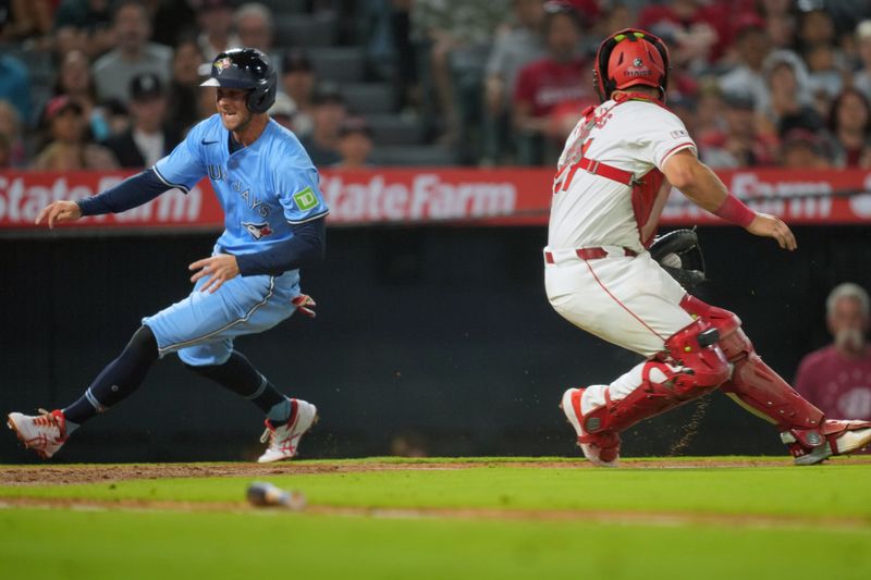 Aug 14, 2024; Anaheim, California, USA; Toronto Blue Jays shortstop Ernie Clement (28) beats a throw to Los Angeles Angels catcher Matt Thaiss (21) to score in the sixth inning at Angel Stadium. Mandatory Credit: Kirby Lee-USA TODAY Sports