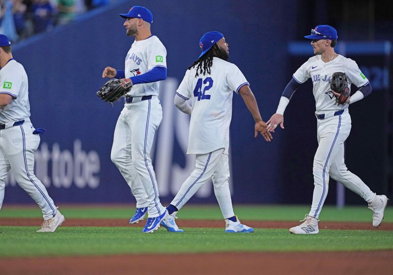 Apr 15, 2024; Toronto, Ontario, CAN; Toronto Blue Jays first base Vladimir Guerrero Jr. celebrates the win with second base Cavan Biggio all wearing number 42 for Jackie Robinson Day at the end of the ninth inning against the New York Yankees at Rogers Centre. Mandatory Credit: Nick Turchiaro-USA TODAY Sports