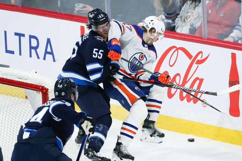 Nov 30, 2023; Winnipeg, Manitoba, CAN; Edmonton Oilers forward Warren Foegele (37) shields the puck from Winnipeg Jets forward Mark Scheifele (55) during the third period at Canada Life Centre. Mandatory Credit: Terrence Lee-USA TODAY Sports