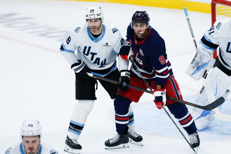 Oct 26, 2025; Winnipeg, Manitoba, CAN; Utah Winnipeg Jets forward Alex Iafallo (9) jostles for position with Utah Mammoth defenseman defenseman Ian Cole (28) during the second period at Canada Life Centre. Mandatory Credit: Terrence Lee-Imagn Images