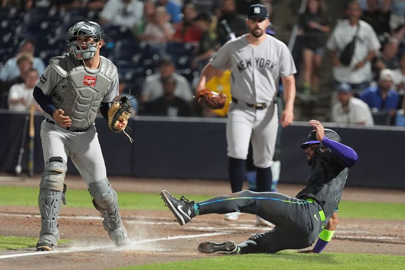 Apr 18, 2025; Tampa, Florida, USA; New York Yankees catcher J.C. Escarra (25) tags out Tampa Bay Rays shortstop Jose Caballero (77) at home during the fifth inning at George M. Steinbrenner Field. Mandatory Credit: Dave Nelson-Imagn Images