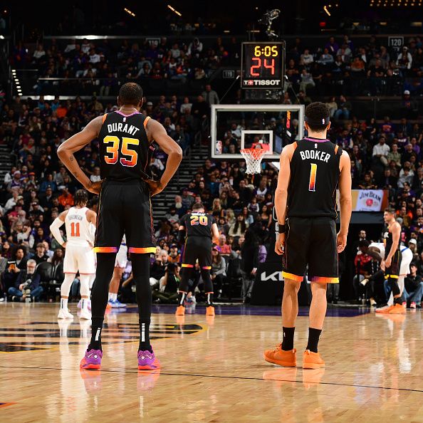 PHOENIX, AZ - DECEMBER 15: Kevin Durant #35 of the Phoenix Suns and Devin Booker #1 look on during the game against the New York Knicks on December 15, 2023 at Footprint Center in Phoenix, Arizona. NOTE TO USER: User expressly acknowledges and agrees that, by downloading and or using this photograph, user is consenting to the terms and conditions of the Getty Images License Agreement. Mandatory Copyright Notice: Copyright 2023 NBAE (Photo by Kate Frese/NBAE via Getty Images)