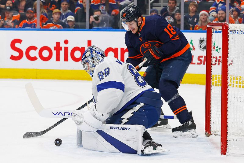 Dec 14, 2023; Edmonton, Alberta, CAN; Edmonton Oilers forward Zach Hyman (18) tries to knock a loose puck past Tampa Bay Lightning goaltender Andrei Vasilevskiy (88) during the first period at Rogers Place. Mandatory Credit: Perry Nelson-USA TODAY Sports