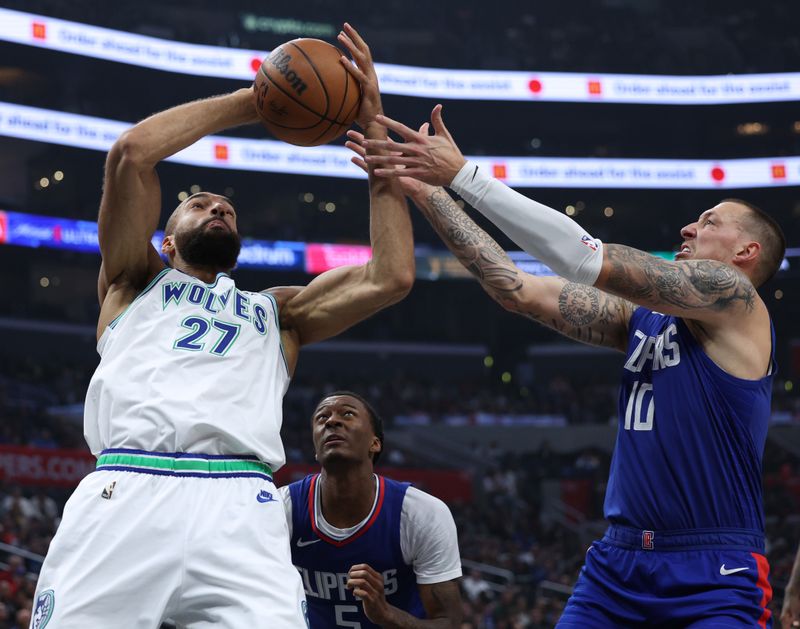 LOS ANGELES, CALIFORNIA - MARCH 12: Rudy Gobert #27 of the Minnesota Timberwolves grabs a rebound in front of Daniel Theis #10 and Bones Hyland #5 of the LA Clippers during the first half at Crypto.com Arena on March 12, 2024 in Los Angeles, California. (Photo by Harry How/Getty Images)