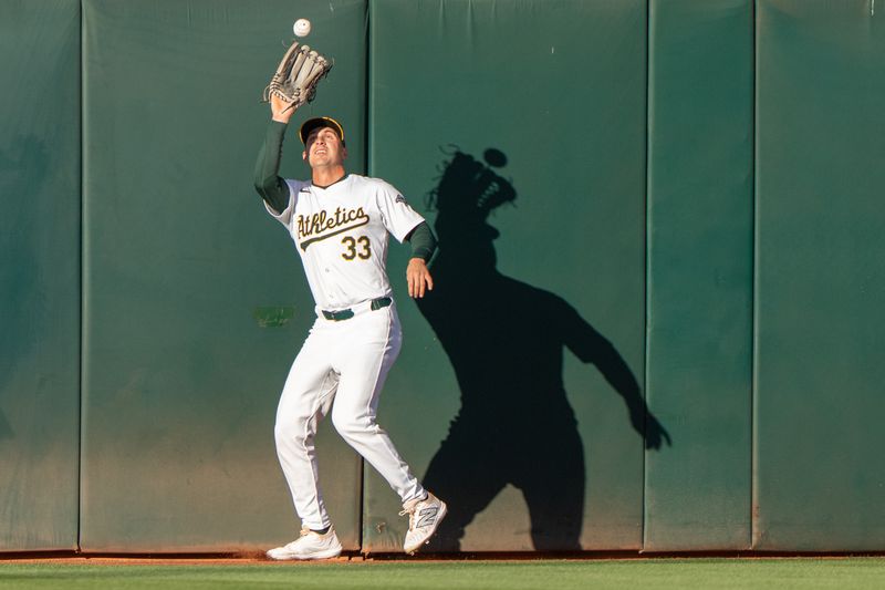 Aug 6, 2024; Oakland, California, USA;  Oakland Athletics outfielder JJ Bleday (33) catches the ball during the first inning against the Chicago White Sox at Oakland-Alameda County Coliseum. Mandatory Credit: Stan Szeto-USA TODAY Sports