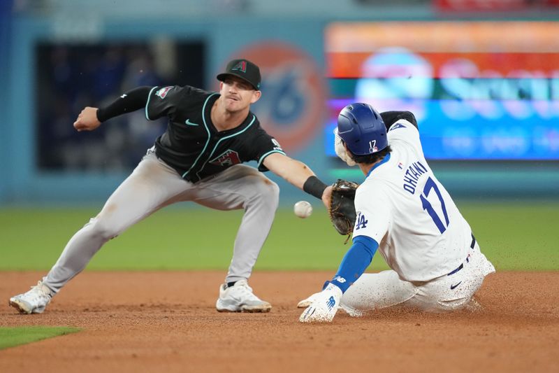 May 21, 2024; Los Angeles, California, USA; Los Angeles Dodgers designated hitter Shohei Ohtani (17) slides into second base for a stolen base against Arizona Diamondbacks shortstop Kevin Newman (18) at Dodger Stadium. Mandatory Credit: Kirby Lee-USA TODAY Sports