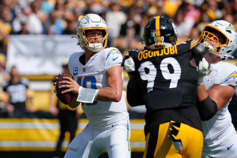 Los Angeles Chargers quarterback Justin Herbert, left, looks for an open receiver during the first half of an NFL football game against the Pittsburgh Steelers, Sunday, Sept. 22, 2024, in Pittsburgh. (AP Photo/Gene J. Puskar)