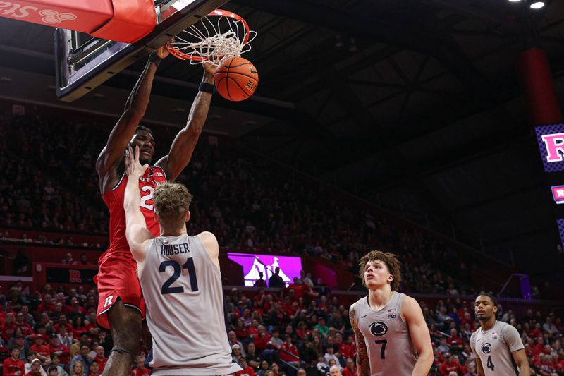 Mar 8, 2026; Piscataway, New Jersey, USA; Rutgers Scarlet Knights center Emmanuel Ogbole (21) dunks as Penn State Nittany Lions forward Justin Houser (21) defends during the first half at Jersey Mike's Arena. Mandatory Credit: Vincent Carchietta-Imagn Images