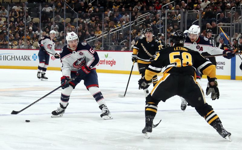 Jan 7, 2025; Pittsburgh, Pennsylvania, USA; Columbus Blue Jackets right wing Kevin Labanc (62) looks to shoot the puck as Pittsburgh Penguins defenseman Kris Letang (58) defends during the second period at PPG Paints Arena. Mandatory Credit: Charles LeClaire-Imagn Images