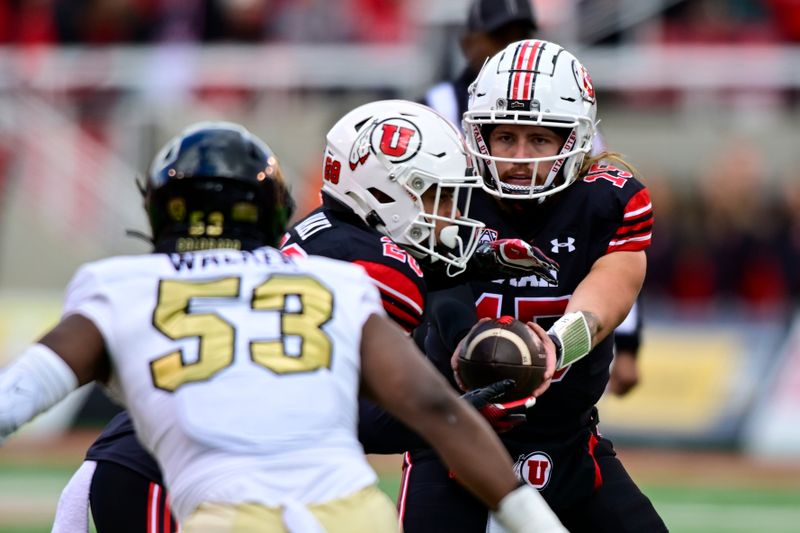 Nov 25, 2023; Salt Lake City, Utah, USA; Utah Utes quarterback Luke Bottari (15) hands the ball off to safety Sione Vaki (28) against the Colorado Buffaloes at Rice-Eccles Stadium. Mandatory Credit: Christopher Creveling-USA TODAY Sports