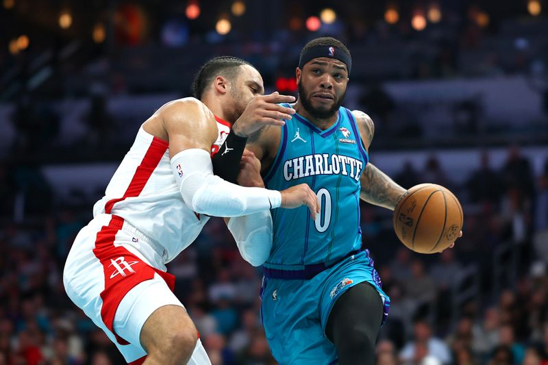 CHARLOTTE, NORTH CAROLINA - JANUARY 26: Miles Bridges #0 of the Charlotte Hornets drives to the basket against Dillon Brooks #9 of the Houston Rockets during the second half of the game at Spectrum Center on January 26, 2024 in Charlotte, North Carolina. NOTE TO USER: User expressly acknowledges and agrees that, by downloading and or using this photograph, User is consenting to the terms and conditions of the Getty Images License Agreement. (Photo by Jared C. Tilton/Getty Images)