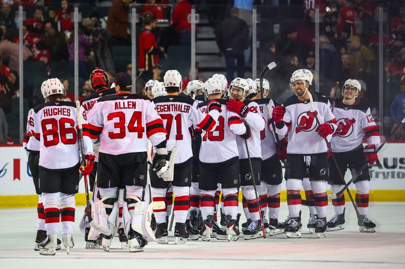 Jan 19, 2026; Calgary, Alberta, CAN; New Jersey Devils players celebrate win over the Calgary Flames during the overtime period at Scotiabank Saddledome. Mandatory Credit: Sergei Belski-Imagn Images
