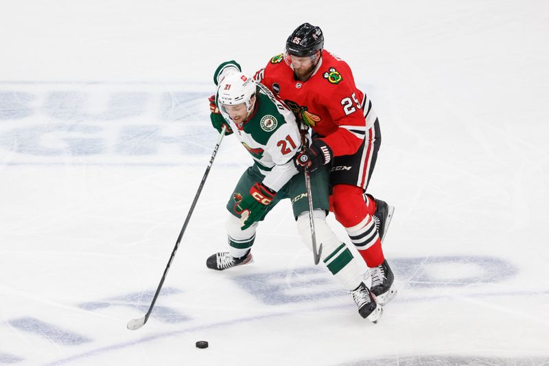 Feb 7, 2024; Chicago, Illinois, USA; Minnesota Wild right wing Brandon Duhaime (21) battles for the puck with Chicago Blackhawks defenseman Jarred Tinordi (25) during the second period at United Center. Mandatory Credit: Kamil Krzaczynski-USA TODAY Sports