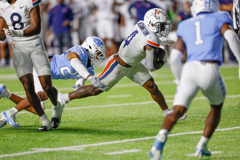 Oct 21, 2023; Chapel Hill, North Carolina, USA; Virginia Cavaliers wide receiver Malik Washington (4) breaks free from North Carolina Tar Heels defensive back Giovanni Biggers (27) as he runs for a touchdown in the second half at Kenan Memorial Stadium. Mandatory Credit: Nell Redmond-USA TODAY Sports