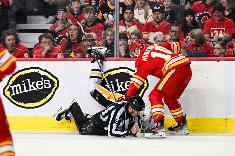 Mar 2, 2024; Calgary, Alberta, CAN; Pittsburgh Penguins center Lars Eller (20) and Calgary Flames center Jonathan Huberdeau (10) collide with a linesman during the second period at Scotiabank Saddledome. Mandatory Credit: Brett Holmes-USA TODAY Sports