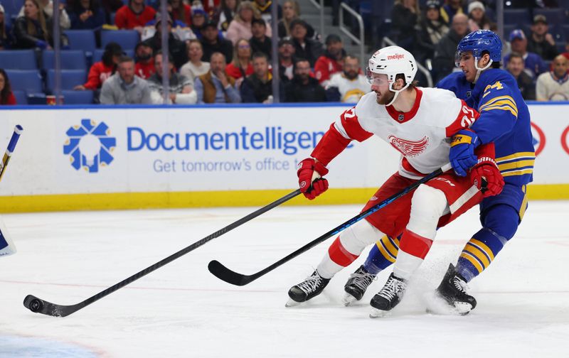 Dec 5, 2023; Buffalo, New York, USA;  Detroit Red Wings right wing Matt Luff (22) takes a shot on goal as Buffalo Sabres center Dylan Cozens (24) defends during the third period at KeyBank Center. Mandatory Credit: Timothy T. Ludwig-USA TODAY Sports