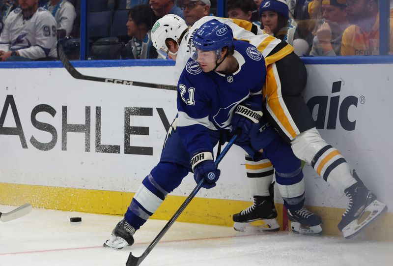 Dec 6, 2023; Tampa, Florida, USA; Pittsburgh Penguins defenseman John Ludvig (7) and Tampa Bay Lightning center Brayden Point (21) skate to control the puck during the third period at Amalie Arena. Mandatory Credit: Kim Klement Neitzel-USA TODAY Sports